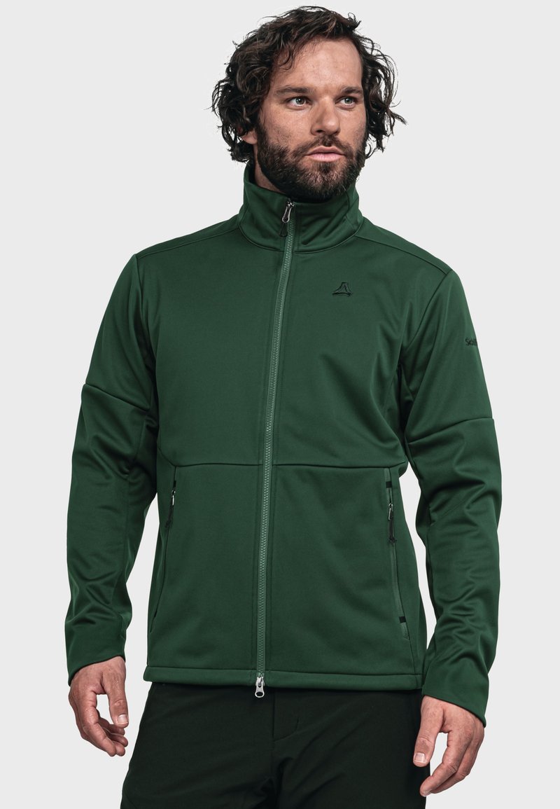 Dark green softshell jacket with high collar, front zip, two side zippers, and subtle branding on the chest and sleeve. Smooth texture.
