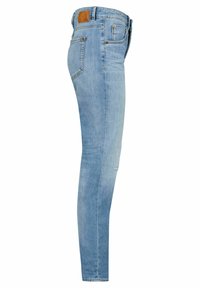 Jeans ajustados de denim azul claro, con una textura suave, cinco bolsillos y un parche de cuero marrón en la cinturilla.