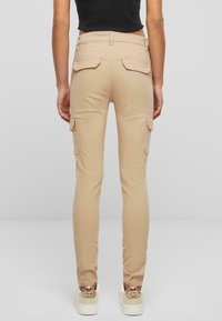 Khaki cargo nohavice so slim fit strihom, s bočnými a zadnými vreckami s klopou. Vyrobené z bavlny s hladkou textúrou.