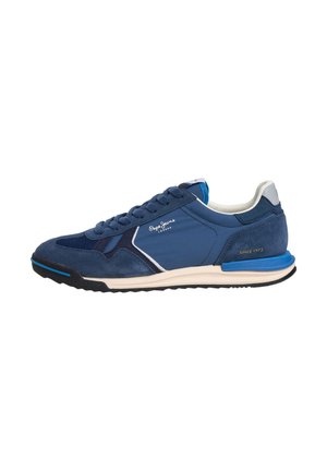 Navyblauwe en zwarte veter sneaker met witte zool, suède en stoffen panelen, en logotekst aan de zijkant en hiel.