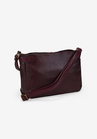 Bolso bandolera de cuero burdeos con una textura suave, cierre con cremallera y correa ajustable. Presenta una forma rectangular sencilla.
