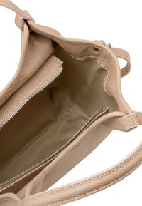 Beżowa skórzana torebka o teksturowanym wykończeniu, z zamykaną na zamek kieszenią wewnątrz i gładką podszewką z tkaniny. W komplecie krótkie uchwyty.