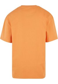 Kortærmet orange T-shirt lavet af bomuld med rund halsudskæring, der har et ensartet design og en glat tekstur uden mønstre.