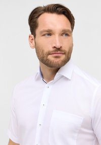 Witte korteblushemd met een button-down kraag, zak en contrasterend blauw ruitpatroon aan de binnenkant van de kraag. Gladde textuur, getailleerd ontwerp.