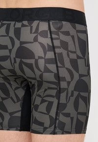 Ανδρικά μποξεράκια σε σκούρο γκρι με μαύρο γεωμετρικό σχέδιο. Διαθέτουν μαύρη ελαστική μέση με ανάγλυφο το όνομα της μάρκας.