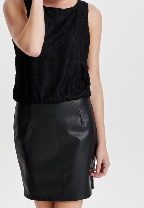 Černý krajkový top bez rukávů v kombinaci s přiléhavou černou koženou tužkovou sukní. Tkanina je hladká s mírným leskem; čisté linie a minimální detaily.