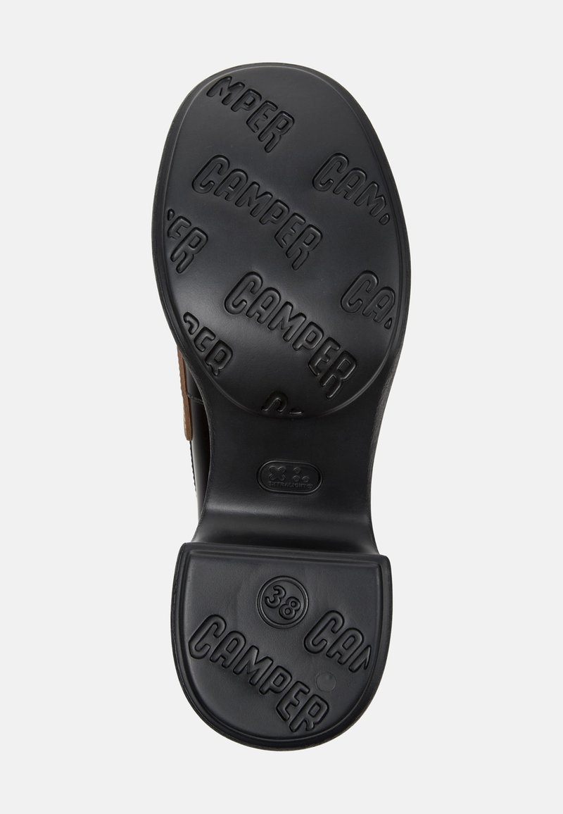Black rubber shoe sole with raised "CAMPER" branding. Round shape with a textured finish. Size 38 indicated on the sole.
