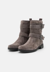 Botines de ante gris con dos correas horizontales y hebillas de metal. Presentan una puntera redonda y un tacón bajo apilado. Superficie texturizada.