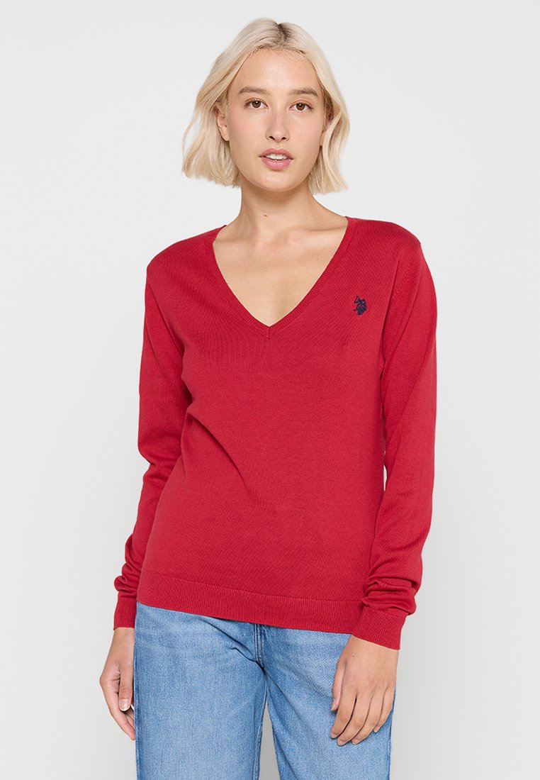 Roter V-Ausschnitt-Pullover mit langen Ärmeln, gerippter Textur und gesticktem Logo auf der linken Brust. Aus weichem Material gefertigt.