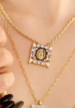 Collier en or avec un pendentif carré comportant une image centrale, entouré de pierres rhines étincelantes et d'accents blancs.