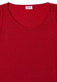 Haut sans manches rouge avec encolure ronde et détails de bretelles tressées sur les épaules, avec une étiquette de marque cousue à l'intérieur du col.