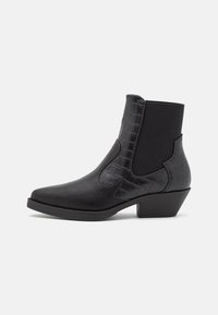 Botines negros con puntera puntiaguda, elaborados en material suave y detalles en relieve de cocodrilo, con laterales elásticos y un tacón bajo y ancho.