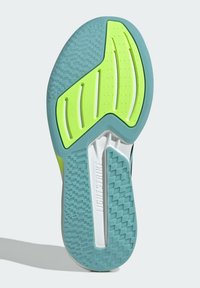 Semelle de chaussure avec des motifs texturés en vert menthe et des accents jaune vif. Présente des rainures flexibles et la marque "Lightstrike".