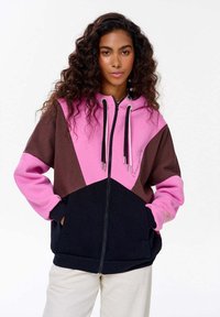 Hoodie w kolorowym blokowaniu w odcieniach różowego, brązowego i granatowego; zamek z przodu, regulowany kaptur i kieszenie z przodu. Wykonany z miękkiego materiału.