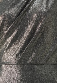 Crni metalni materijal s glatkom, sjajnom teksturom, koji sadrži dijagonalne pruge. Površina odražava svjetlost, stvarajući sjajeći efekt.