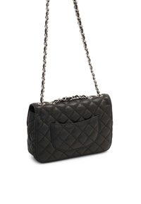 Sac à bandoulière en cuir noir matelassé avec bandoulière chaîne argentée et poche extérieure incurvée à l'arrière.
