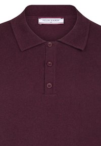 Burgunderfarbendes Polo-Shirt aus weichem Stoff, mit einem gestrickten Kragen und einer Knopfleiste mit drei Knöpfen in passender Farbe. Markenlabel sichtbar.