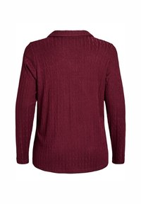 Maglione borgogna a maniche lunghe con motivo a trecce, collo e una texture morbida. La vista posteriore mostra un orlo liscio e una forma aderente.