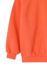 Narančasti dugi rukav pulover s rebrastim manšetama i pojasom, prikazan na bijeloj pozadini, prikazujući samo donji dio rukava i bočni dio.