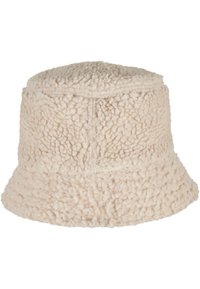 Creme bucket hat lavet af tekstureret, fluffy materiale med en rund krone og bred skygge, der har synlige syninger.