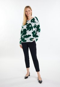 Groene trui met bloemenpatroon, met lange mouwen en ronde hals. Gekocht met zwarte, cropped broek en zwarte hakken. Zachte textuur.