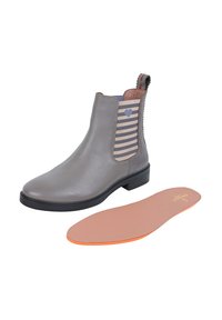 Stivaletto in pelle grigia con pannello elastico a righe caratterizzato da un piccolo cuore. Include una soletta rimovibile di colore marrone chiaro con un accento arancione.