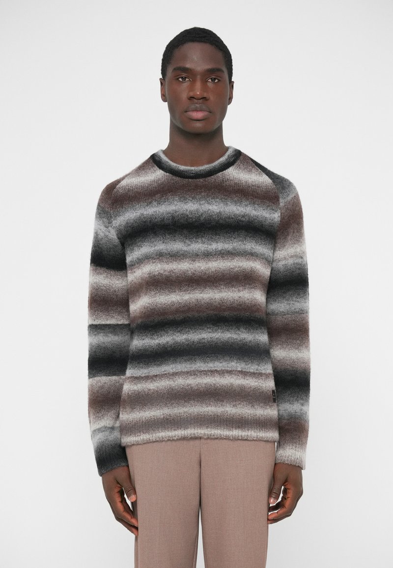 Πλεκτό πουλόβερ με οριζόντιες ρίγες σε σκούρο γκ�ρι, ανοιχτό γκρι και καφέ. Στρογγυλή λαιμόκοψη, ριμπ μανσέτες και απαλό ύφασμα.