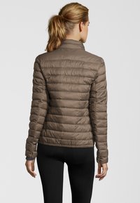 Brun, vadderad pufferjacka med hög krage och elastiska ärmslut. Har en figursydd design och en slät, glänsande yta.