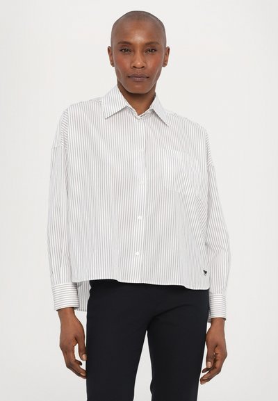 Witte shirt met dunne verticale marineblauwe strepen, met een button-down kraag, een enkele borstzak en een verlengde achterzoom. De stof lijkt glad en licht van gewicht.