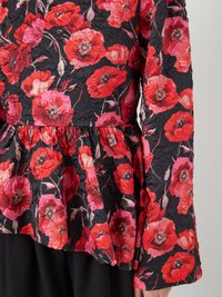 Blusenshirt mit Floral-Design im Peplum-Stil, das rote und pinke Mohnblumenmuster auf schwarzem Hintergrund zeigt, aus strukturiertem Stoff und mit langen Ärmeln.