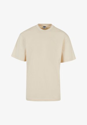 Beige Baumwoll-T-Shirt mit Rundhalsausschnitt und kurzen Ärmeln, das einen lockeren Schnitt und minimale Nahtdetails aufweist. Lässiges und vielseitiges Design.