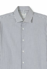 Striped button-up shirt in white and navy. Features a classic collar, small buttons, and a body fit design with breathable fabric.