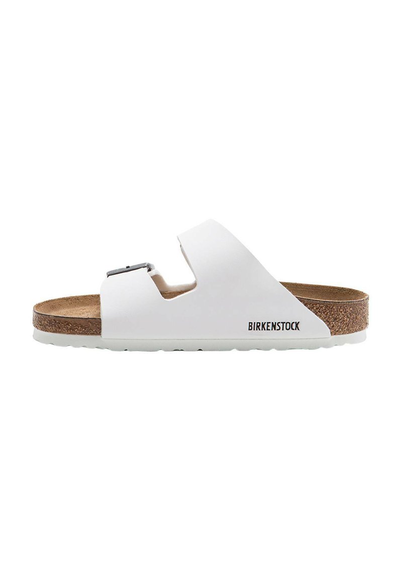 Sandale Birkenstock blanche avec un fond en liège, boucle ajustable, design ouvert et semelle en caoutchouc texturée. Marque visible sur le côté.