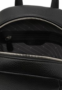 Black leather backpack with a textured finish, featuring a zippered main compartment and a black and white striped fabric lining.
