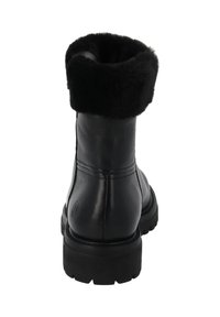 Bota de cuero negra hasta el tobillo con un suave forro de piel negra en el puño, suela de goma y detalle de logo circular en la parte trasera cerca de la suela.