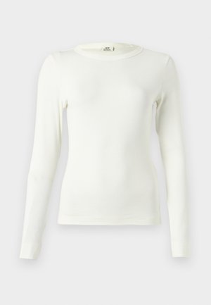 Valge ribikangasest pikkade varrukatega pluus, millel on ümmargune kaelus ja keha järgnev lõige. Varrukate otsad on ilma õmblusteta.