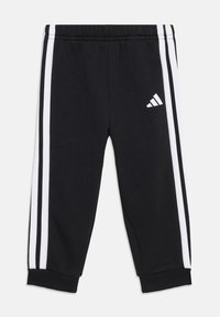 Black sweatpants with white side stripes and an embroidered Adidas logo on the left thigh, featuring an elastic waistband and cuffed ankles.