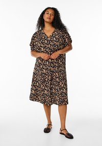 Robe noire fluide avec un motif léopard dans des tons de marron et de beige, dotée d'un décolleté en V et de manches courtes.