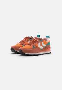 Chaussures de sport orange et marron en daim et mesh ; présentent des accents blancs et turquoise, des lacets, et une semelle en caoutchouc texturée.