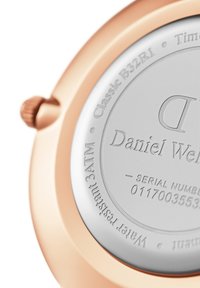 Rose gold watch with stainless steel back. Engravings include brand name "Daniel Wellington" and additional technical details.
