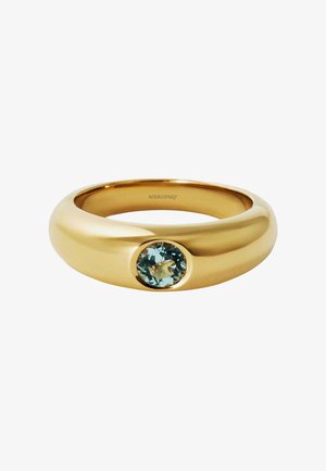 Anillo de oro con una banda lisa y redondeada que presenta una gema circular de color azul claro engastada en una caja. Diseño minimalista y acabado pulido.