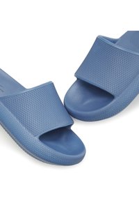 Blue slide sandals with a textured upper strap and patterned sole. Made of flexible material; open toe design for breathability.