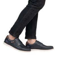 Dark blue perforated leather shoes with brown accents and white rubber soles, featuring a classic lace-up design and textured surface.