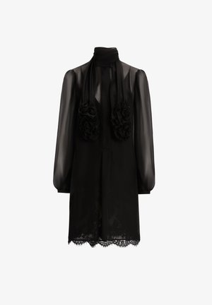 Vestido de chiffón negro con mangas largas, cuello alto y acentos florales fruncidos en la parte delantera. Presenta un borde de encaje en el dobladillo.