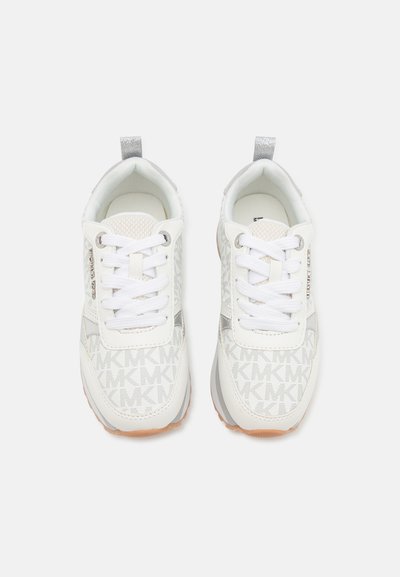 Hvite sneakers med et mønstrete materiale som har bokstavene "MK", runde skolisser, sølvdetaljer og en teksturert gummisåle.
