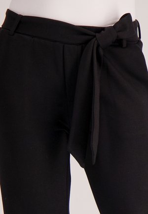 Zwarte culottes met een brede tailleband, voorzien van een strikdetail aan de voorkant en zijzakken, gemaakt van een zachte, gestructureerde stof.