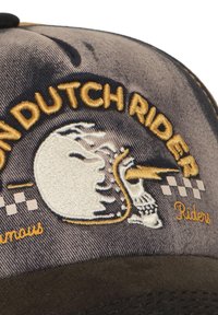 Gorra de béisbol con tela gris oscura, con bordado amarillo de una calavera con un rayo y acentos de tablero de ajedrez, visera texturizada.