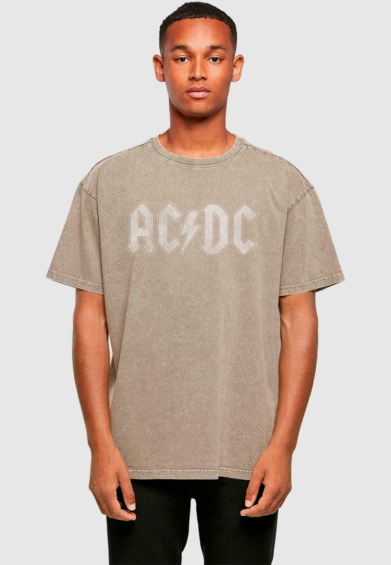 Per didelį, trumpomis rankovėmis marškinėlį iš nublukusio smėlio spalvos medvilnės. Puošia didelis AC/DC logotipas su žaibu. Apvalus iškirpimas, laisvas siluetas.