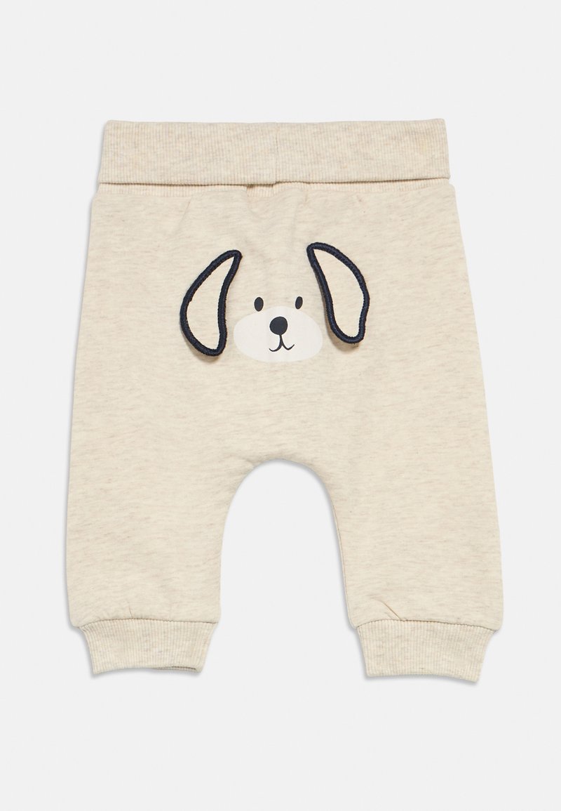 Παντελόνια μπεζ ανοιχτού χρώματος για νήπια με σχέδιο προσώπου σκύλου με μαύρες περιγράμματα, ριμπ ζωνάκι μέσης και μανσέτες. Μαλακό, άνετο ύφασμα.