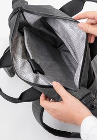 Borsa tote in tessuto grigio con apertura non zip, che mostra un interno foderato in argento con motivo a griglia e un compartimento per l'organizzazione.